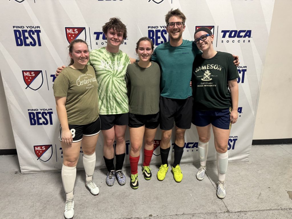 Grad students Cecilia Vanden Heuvel, Zach Smith, Malinda Barberio, Sam Anderson, and Lena Berry pose in their soccer gear